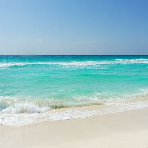 turquoise ocean water, gentle waves rolling onto the beach