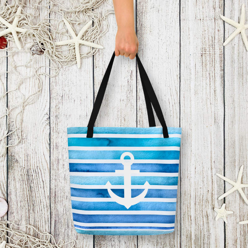 Custom tote held in hand on weathered wood, personalized beach bag with anchor for beach lovers