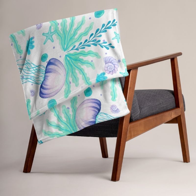 Coastal throw blanket in aqua and lavender jellyfish pattern draped over chair — 50x60 beach throw decor