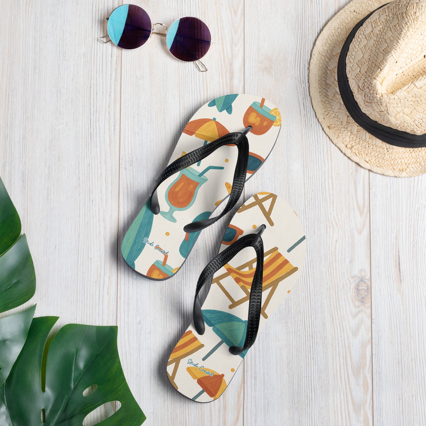 Flip flops for women with ocean inspired design on background styled with tropical leaves and straw hat for beach lifestyle