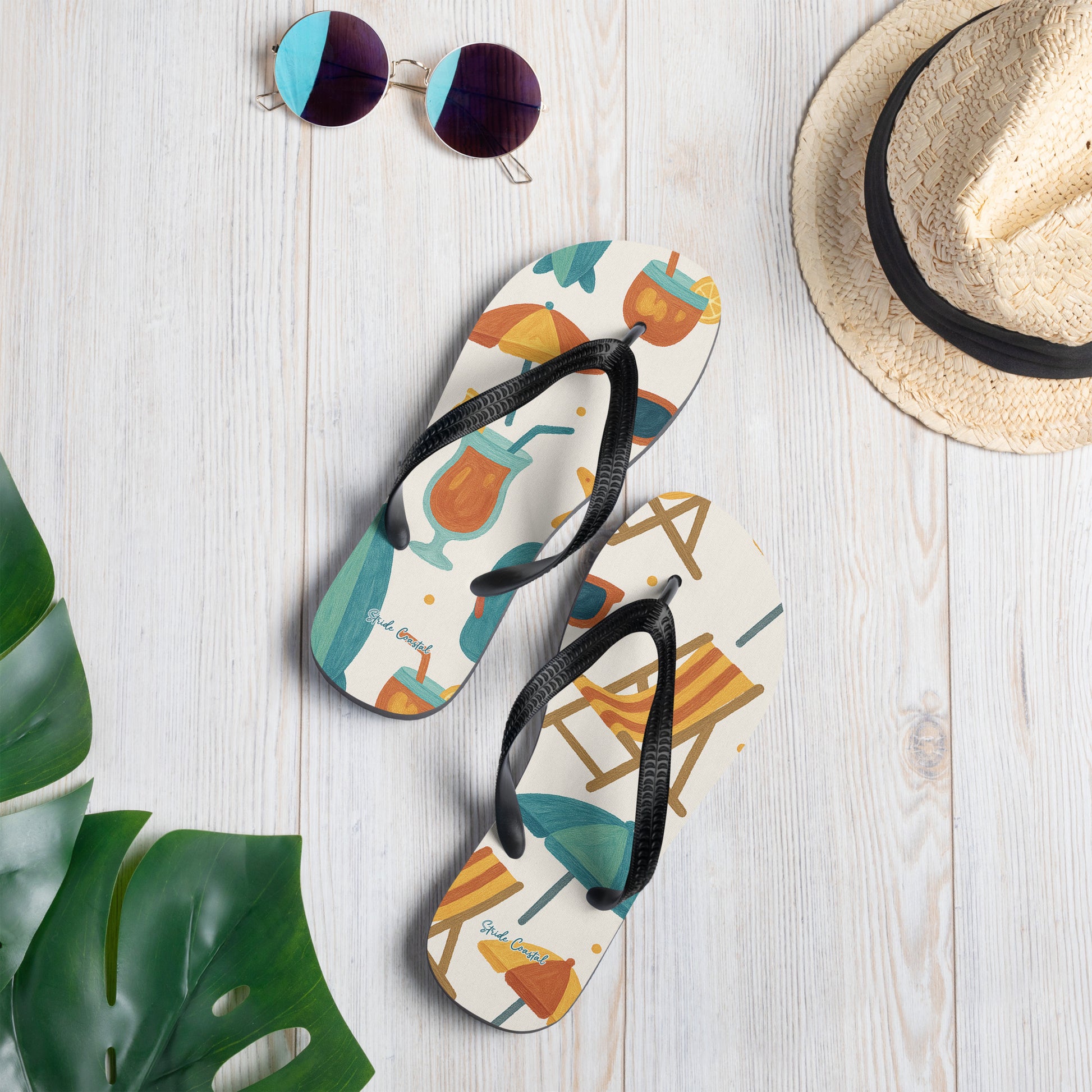 Flip flops for women with ocean inspired design on background styled with tropical leaves and straw hat for beach lifestyle