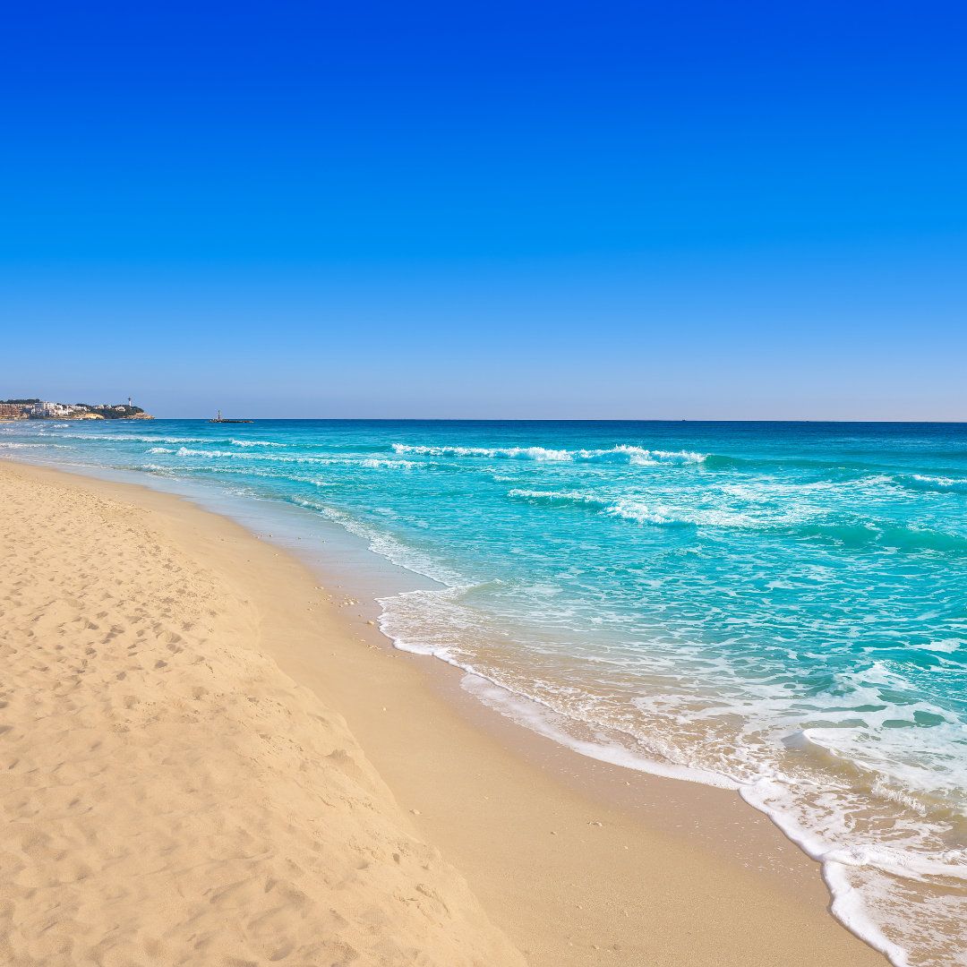 Beachscape showing the waves rolling in and warm sand