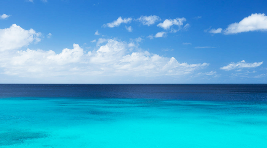 Vibrant turquoise ocean under a bright blue sky, illustrating a classic blue scene proven to reduce stress.