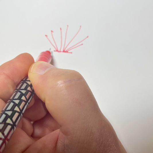 hand drawing radial lines on a white paper