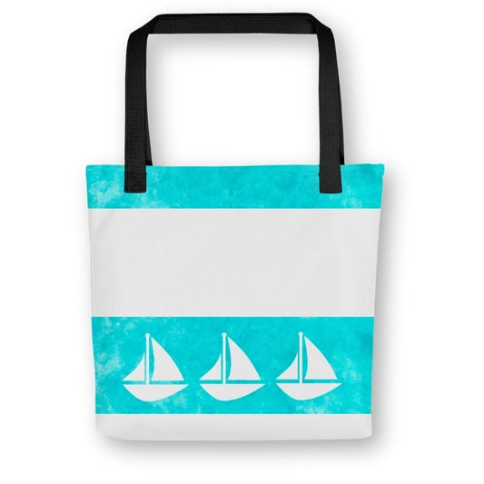 Front view of teal tote bag with three white sailboats across a turquoise watercolor stripe, black handles, and a coastal-inspired design.

