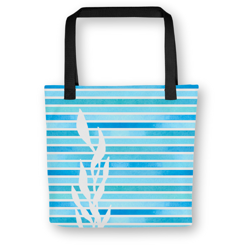 Front view of blue tote bag with kelp silhouette over horizontal watercolor stripes, black handles, and a coastal-inspired design.
