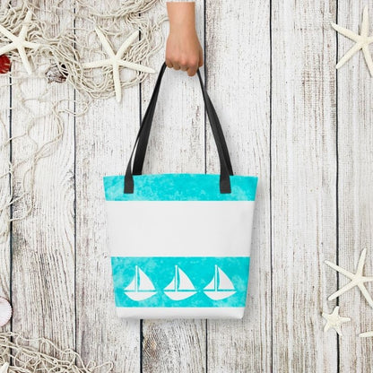 Styled flat-lay of the coastal tote held by hand, with whitewashed wood and starfish accents for a beachside vibe.
