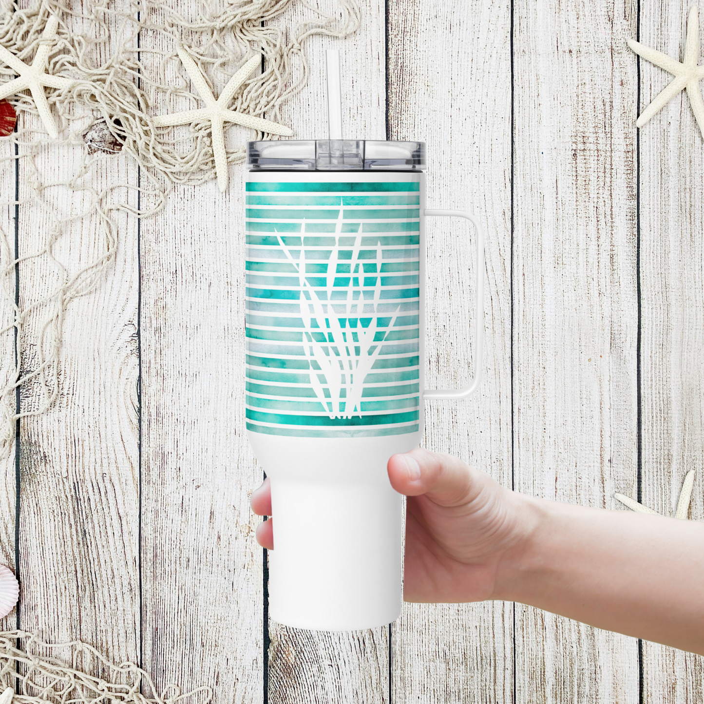 Hand holding a Coastal 40 oz tumbler with turquoise sea kelp fronds, the best coastal travel mug for everyday hydration.
