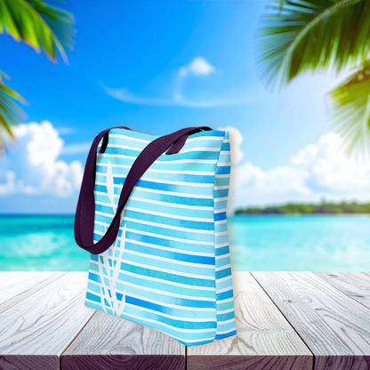 Side view of beach tote handbag with watercolor stripe accents and kelp motif, styled against a tropical ocean backdrop.
