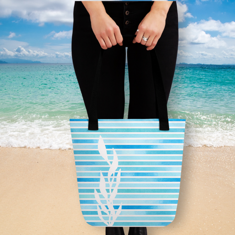 women holding blue tote handbag in front of a beach beach scene
