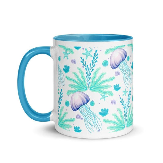 Colorful coffee mug with handle on the left side, blue color inside and on handle, lavender jellyfish and aqua sea kelp design
