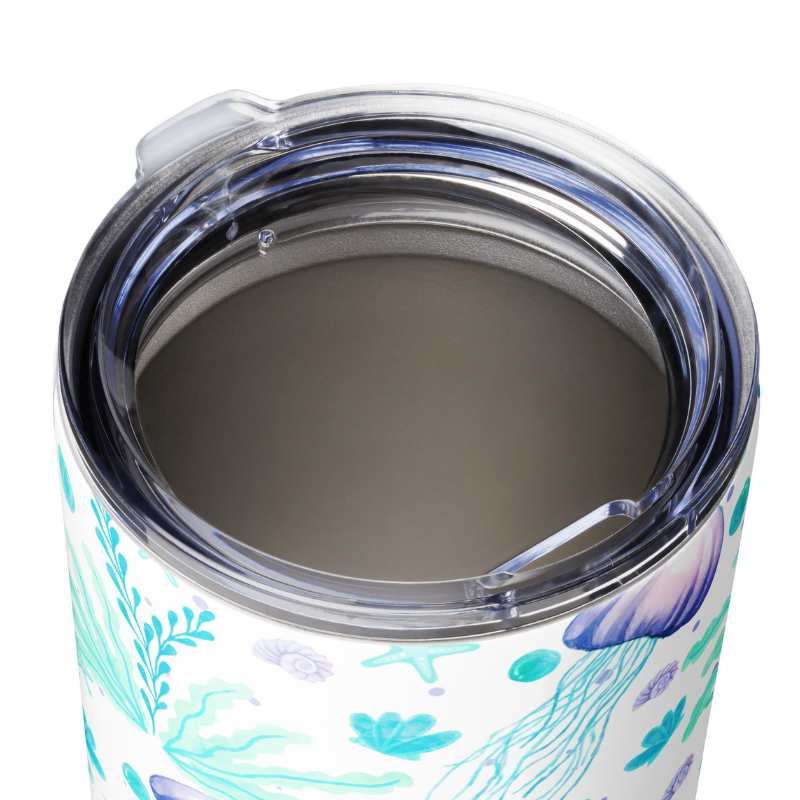 angled view of travel coffee mug best with lid on, featuring ocean-inspired artwork.
