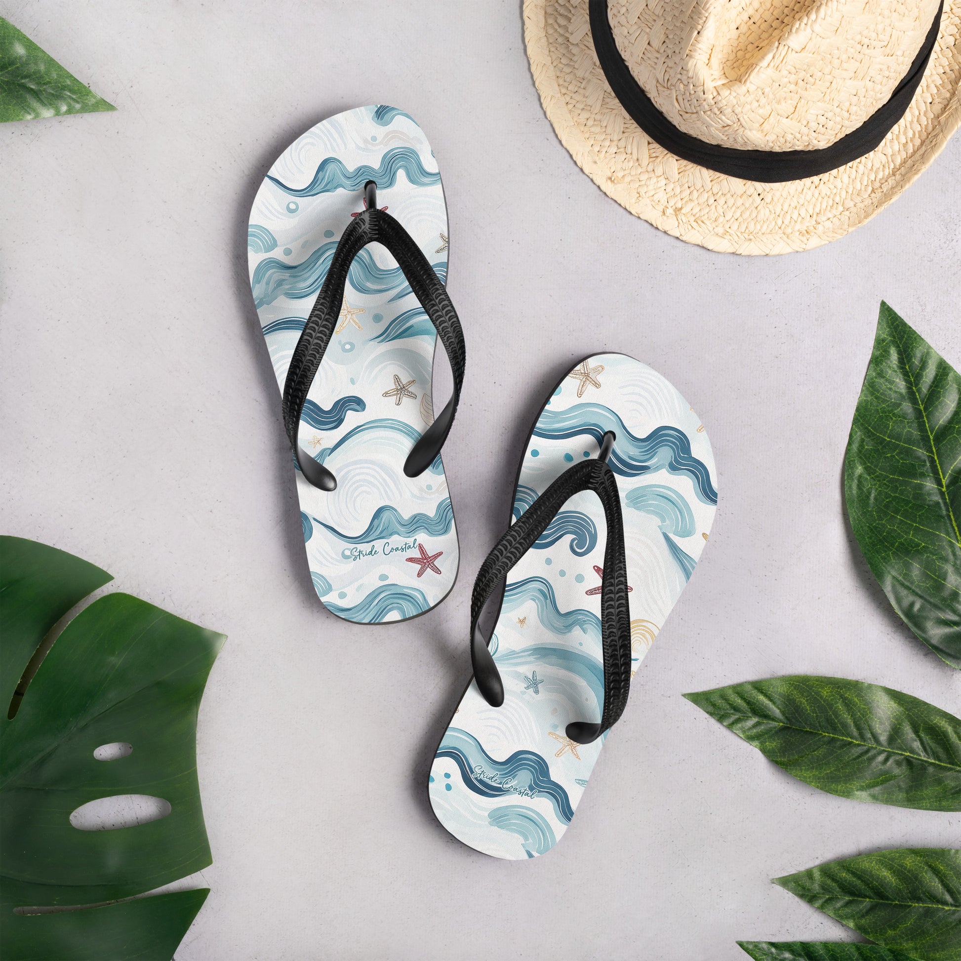 flip flops flat on the ground next to a hat and some decorative plants